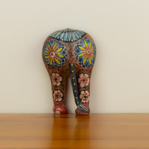 Rear view of a 20cm large hand-painted wooden elephant with intricate yellow and blue floral motifs.
