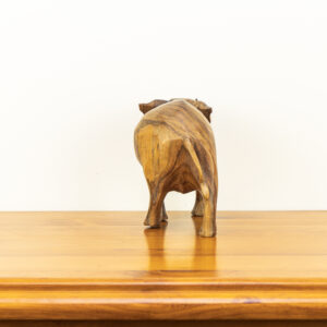 Close up of hand-carved Balinese elephant showing dark natural wood grain lines and upward trunk.