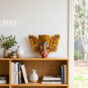 Sri Lankan Gurulu Raksha mask displayed as colourful wall art