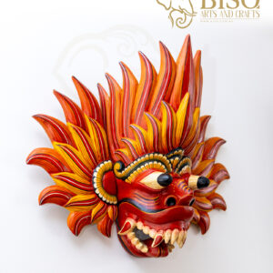 Side view of hand-carved Gini Raksha mask showing projecting eyes and fangs