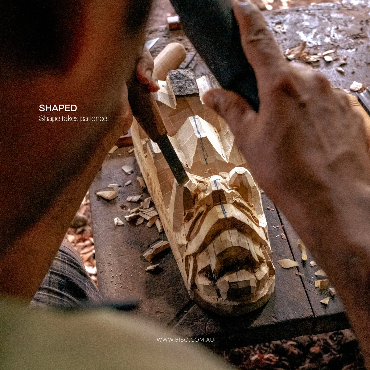 Artisan shaping a wooden mask face with a hand chisel and mallet in a Sri Lankan workshop – authentic handcrafted wood carving