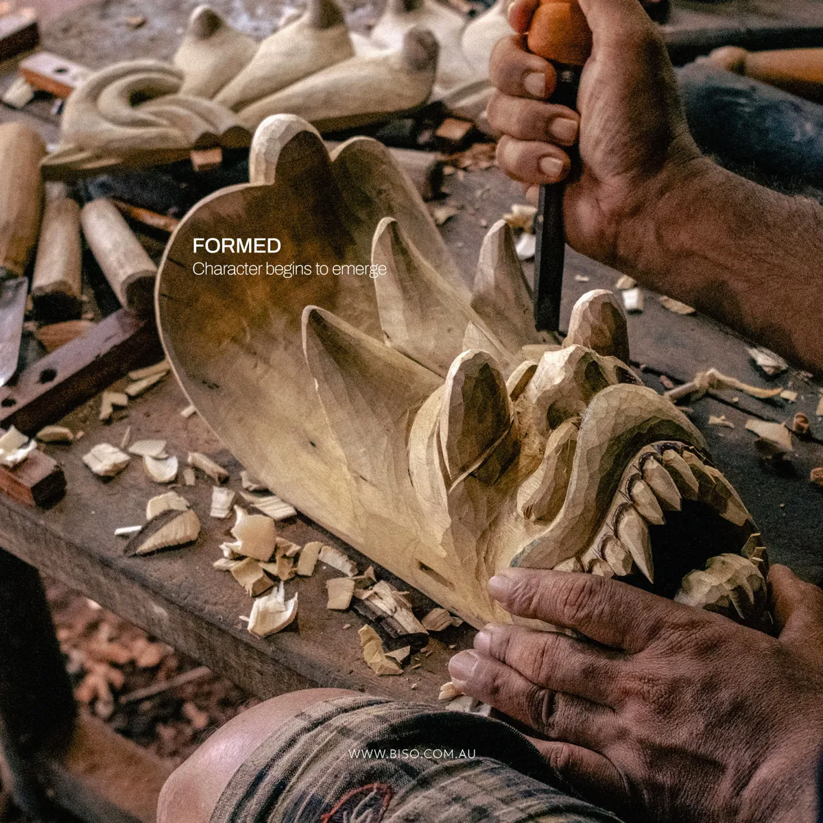 Close-up of hands carving the fangs and teeth of a Naga Raksha mask in raw wood – genuine Sri Lankan handcraft