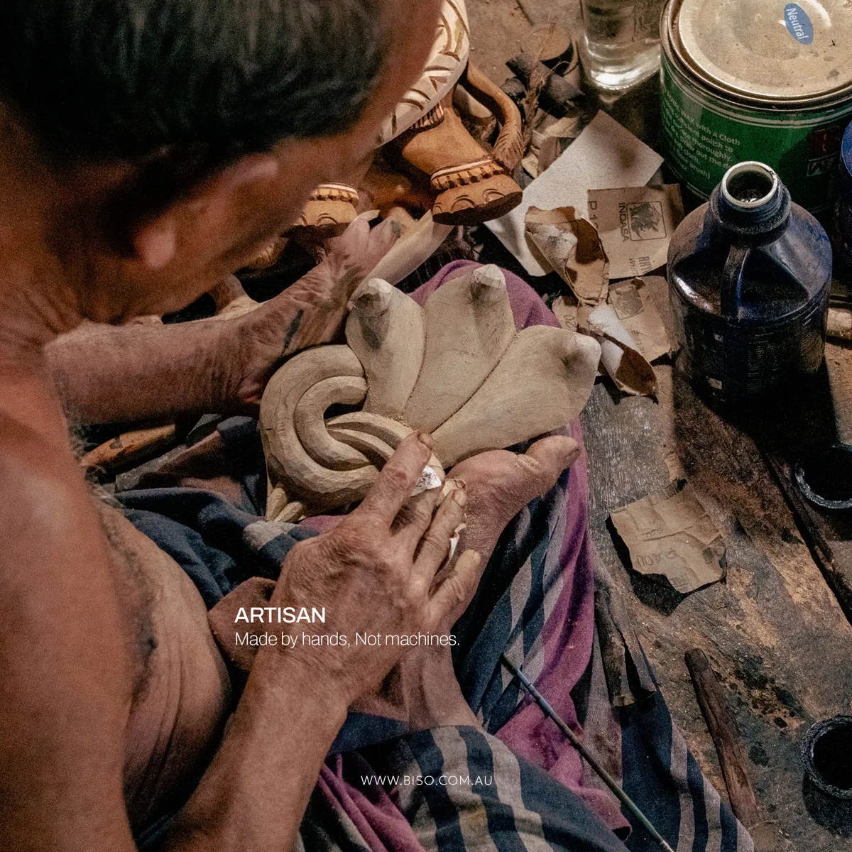 Senior Sri Lankan artisan hand-sanding the cobra hood of a wooden mask – supporting traditional artisans with fair work