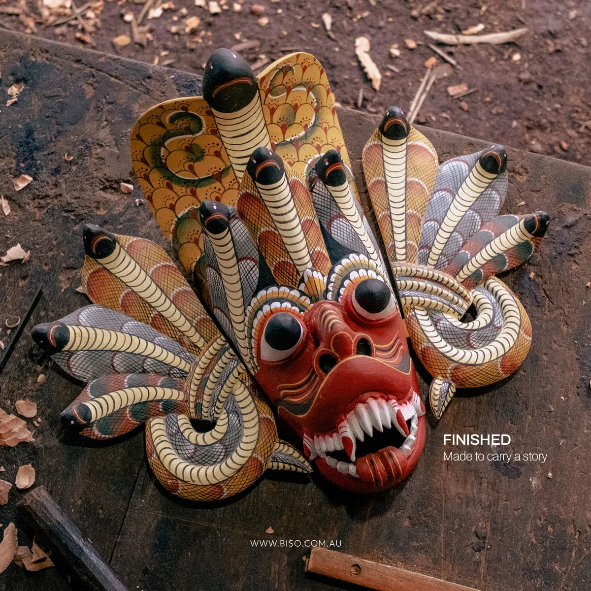 Finished hand-painted Naga Raksha cobra demon mask in red, yellow and cream – authentic Sri Lankan wooden mask by BISO