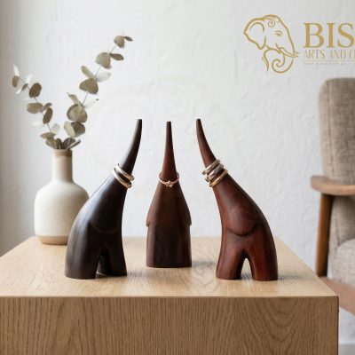 Three hand-carved mahogany elephant ring holders in dark brown