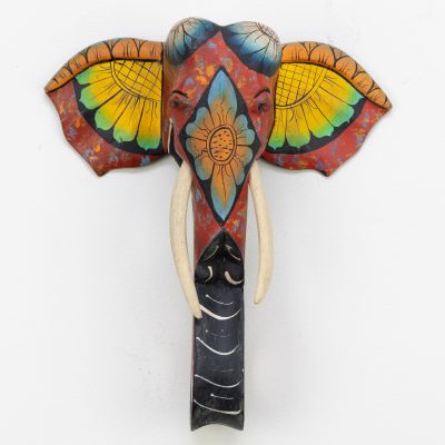 Front-facing hand-painted elephant wall sculpture, red and yellow floral ears, natural wood carving for BISO Heritage Collection.